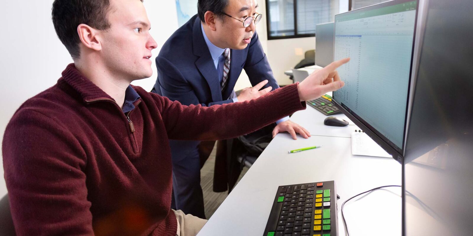 iit_landing-page_business_hero Professor showing student information on computer monitor