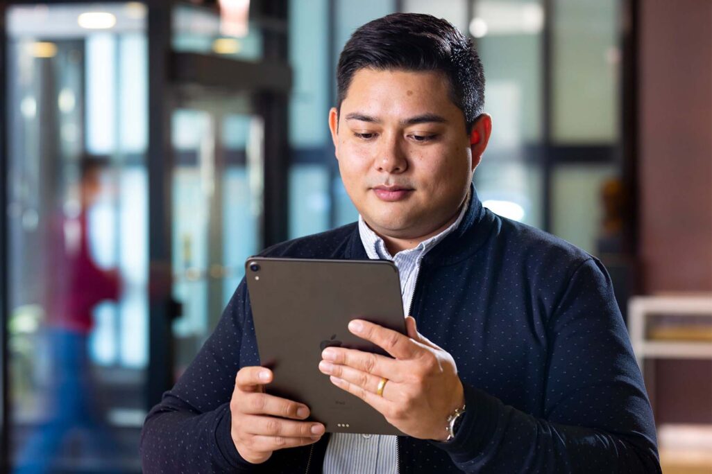 Student of business analytics program reading information on an iPad