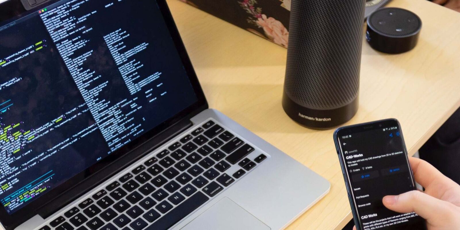 laptop open to code on table net to water bottle